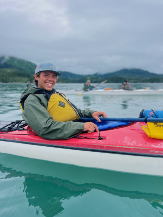 Person sitting in a sea kayak smiling.