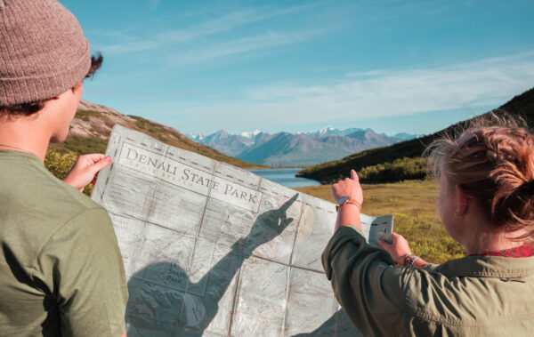 two people looking at a map of Denali State Park figuring out their route for backpacking