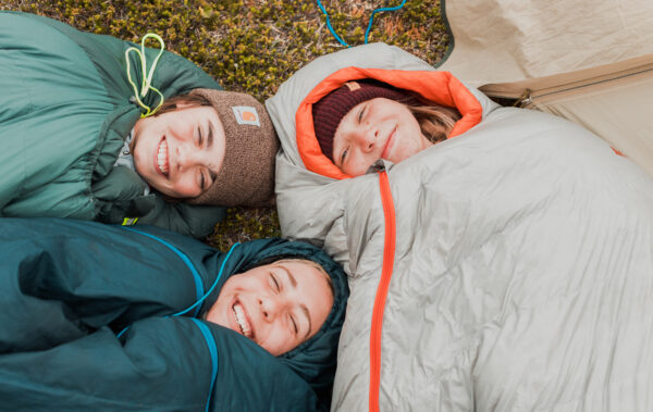 2 students wrapped up in sleeping bags smiling