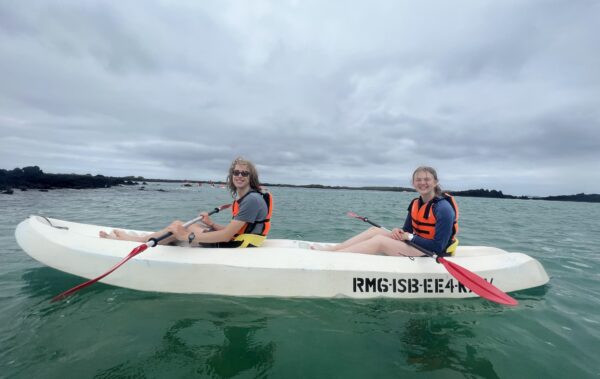 two students in a sea kayak on the ocean