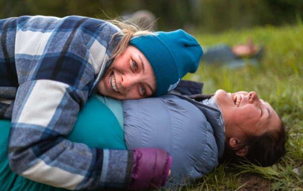 Person laying on top of another in a sleeping bag