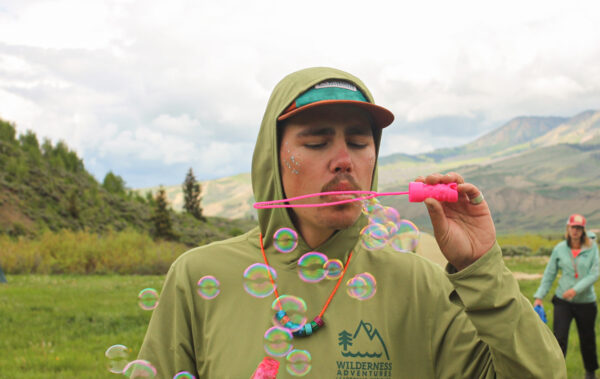 Person blowing bubbles in the mountains.