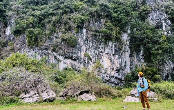 Man looking up at a rock wall in Vietnam