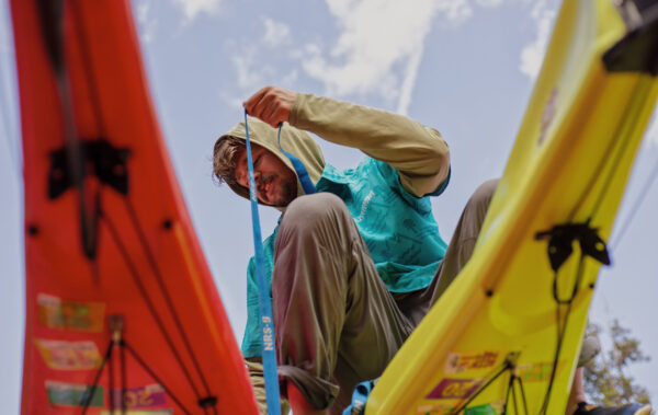 Person strapping kayaks down to a trailer