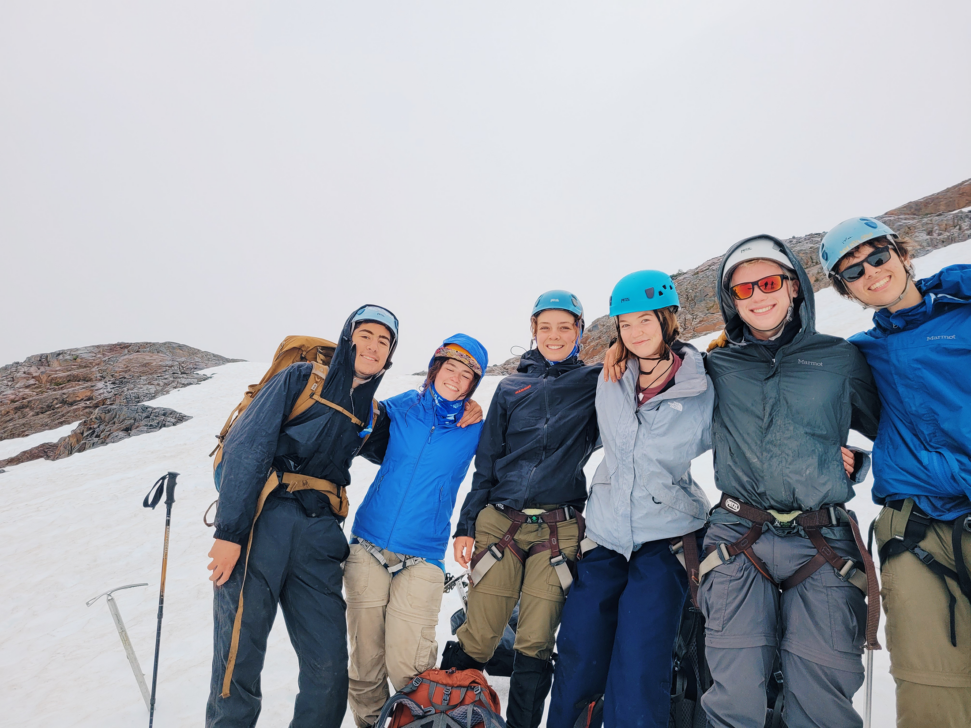 Group of people smiling while mountaineering.