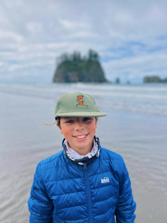 Young boy smiling on Cannon Beach in Oregon.