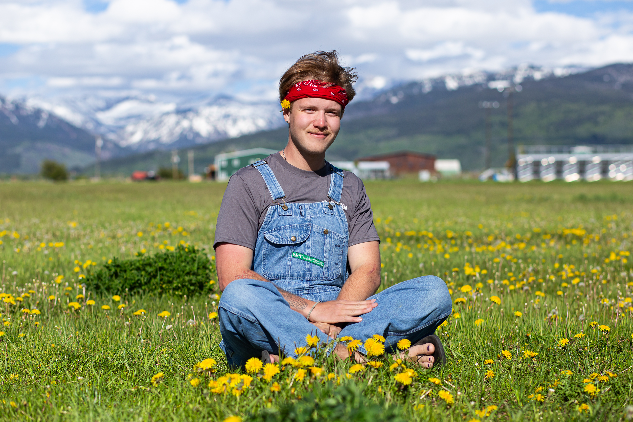 Photo of a person sitting in a field smiling.