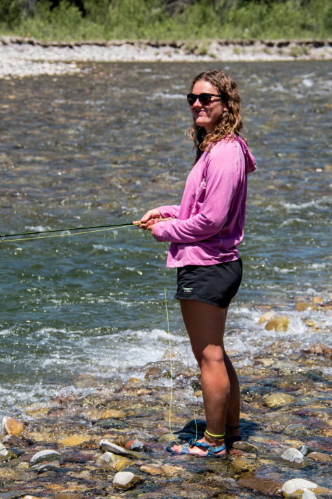 Girl fly fishing in a river.